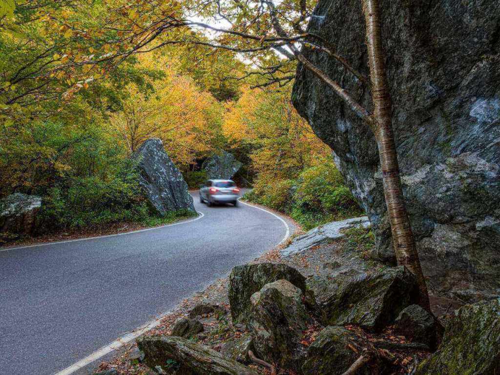Driving through Smugglers’ Notch with tall rock walls and forested scenery