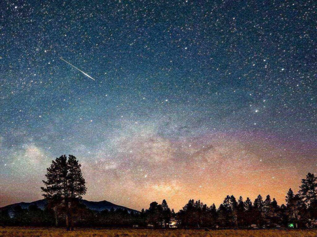 Stargazing over dark volcanic terrain near Sunset Crater