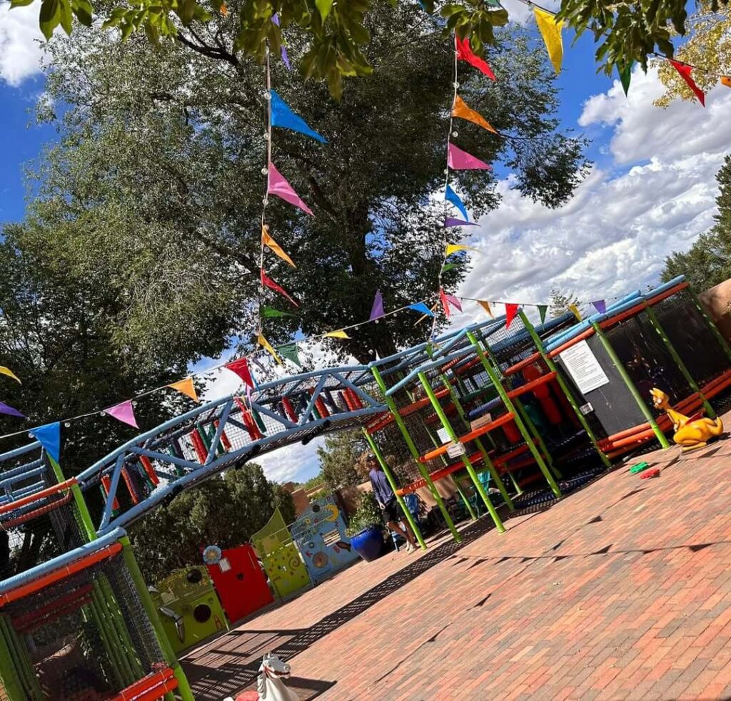 Colorful outdoor play courtyard at Twirl Toy Store in downtown Taos