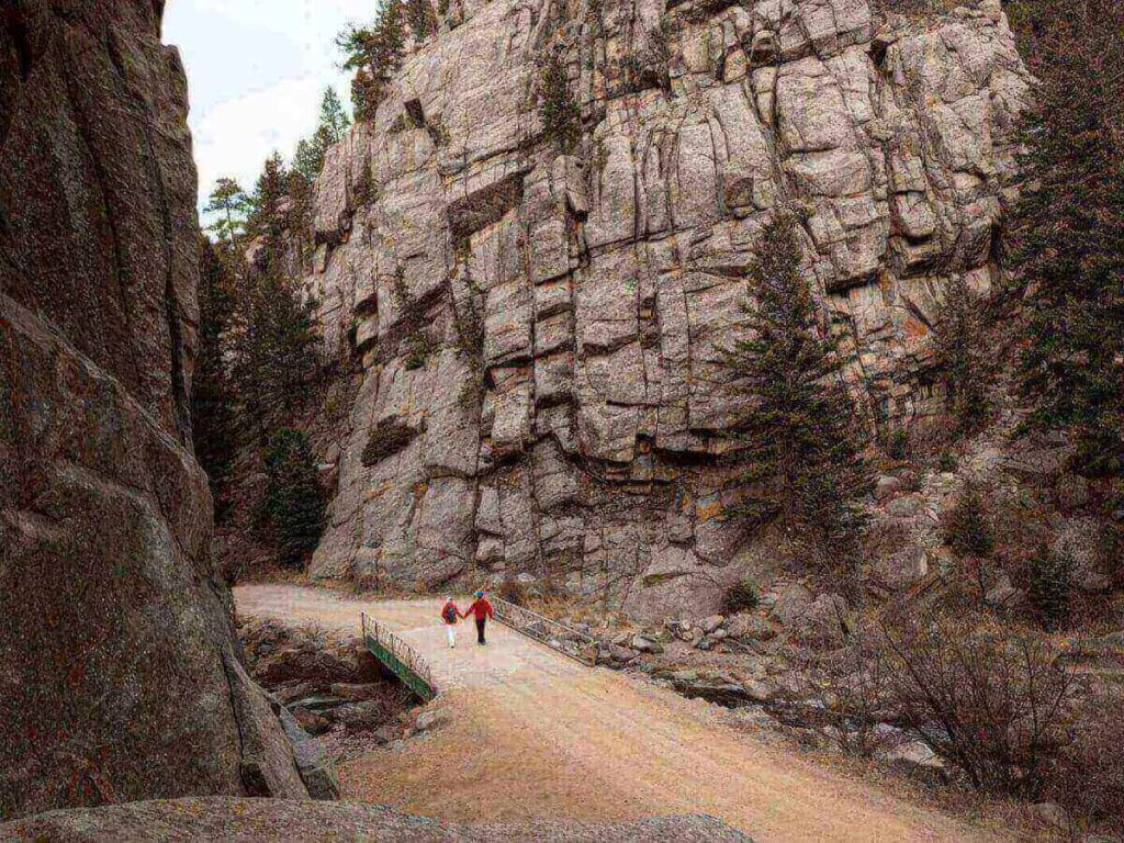 Boulder Canyon road with creek and tall rock walls.