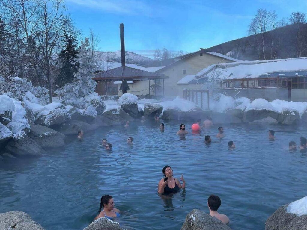 Steaming outdoor hot springs surrounded by snow at Chena Hot Springs Resort