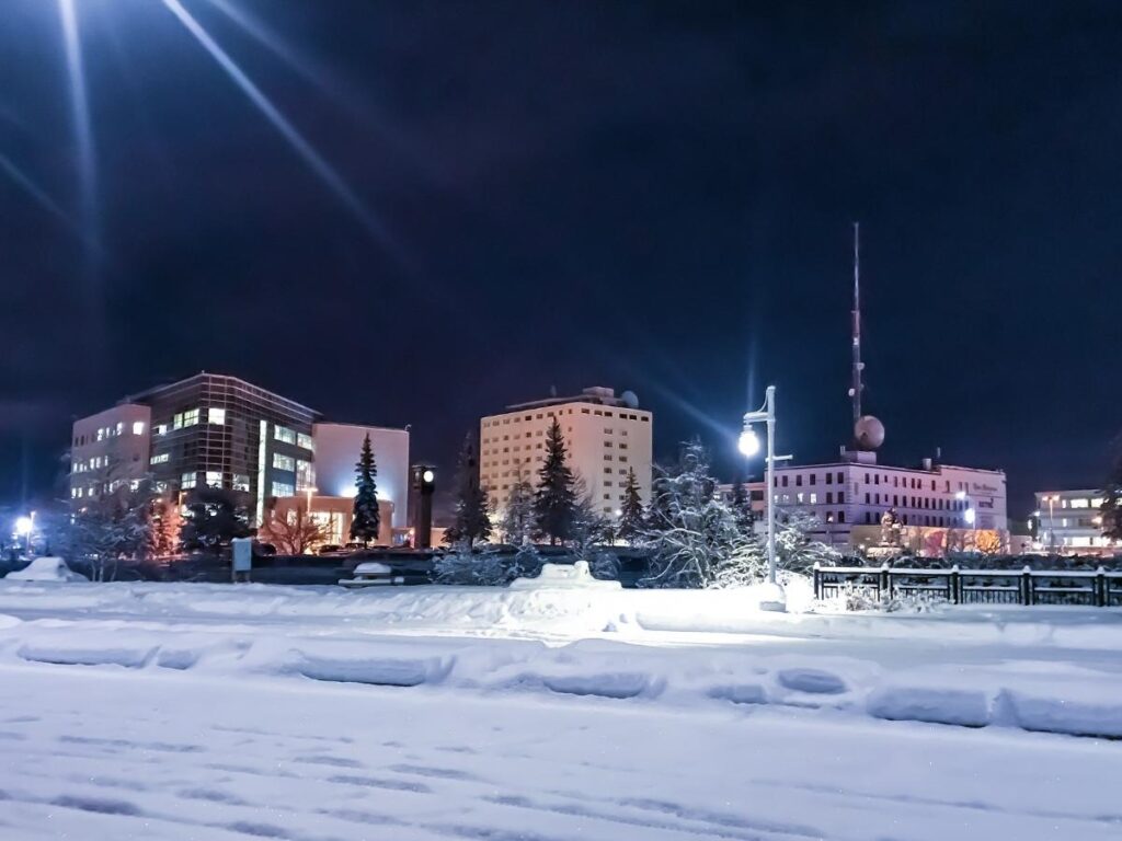 Winter view of Fairbanks, Alaska with snow-covered buildings and glowing lights