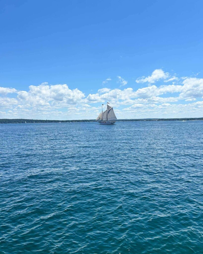 Sailboats cruising across Grand Traverse Bay at sunset