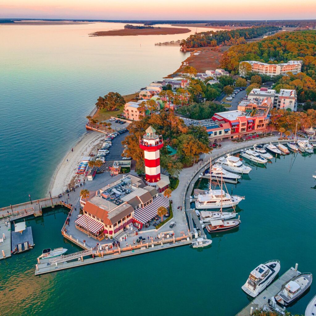 Red and white striped lighthouse at sunset in Harbour Town