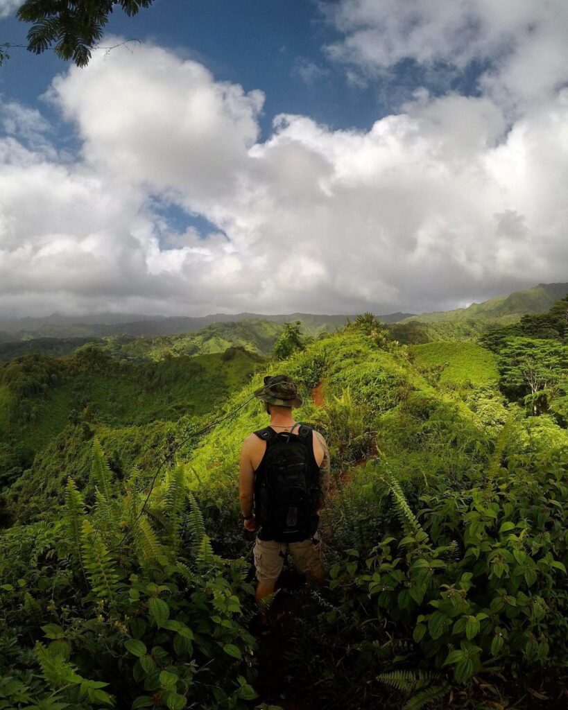 Grassy trail on Kuilau Ridge surrounded by jungle and distant mountains