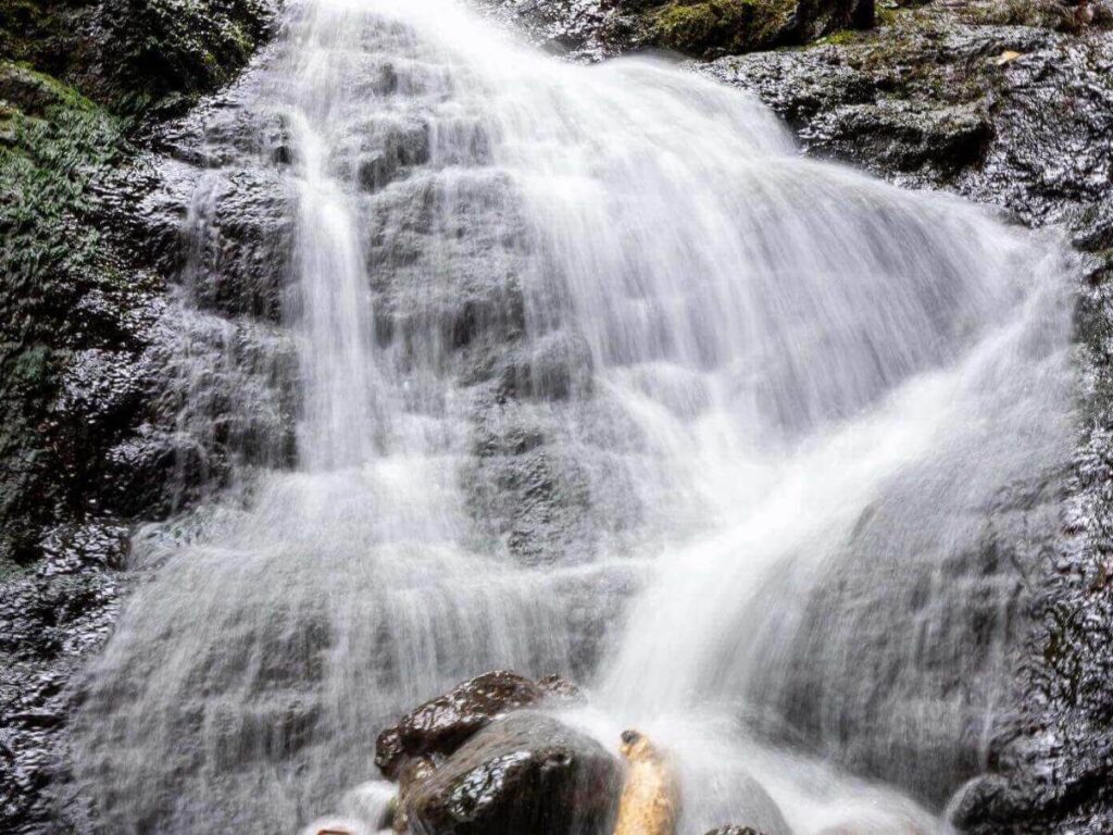 Likeke Falls small waterfall surrounded by dense greenery in Oahu