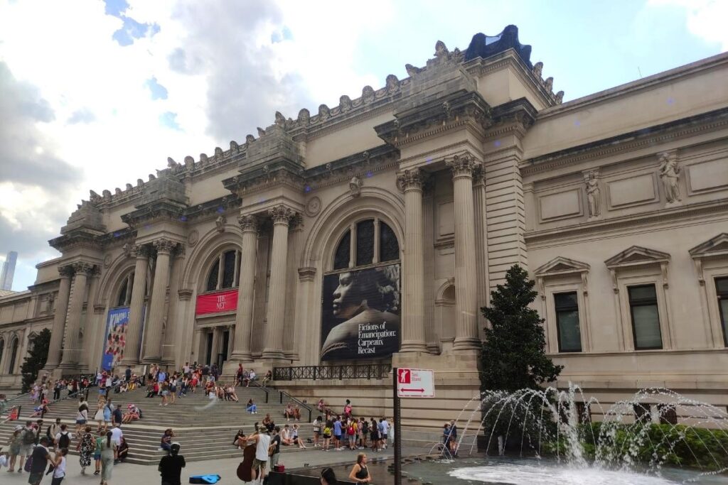 Visitors sitting on the steps of the MET Museum