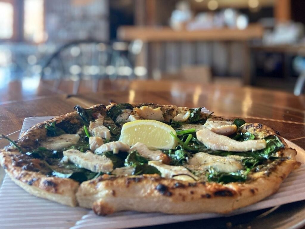 Fresh pizza on the table inside Moose’s Tooth Pub & Pizzeria