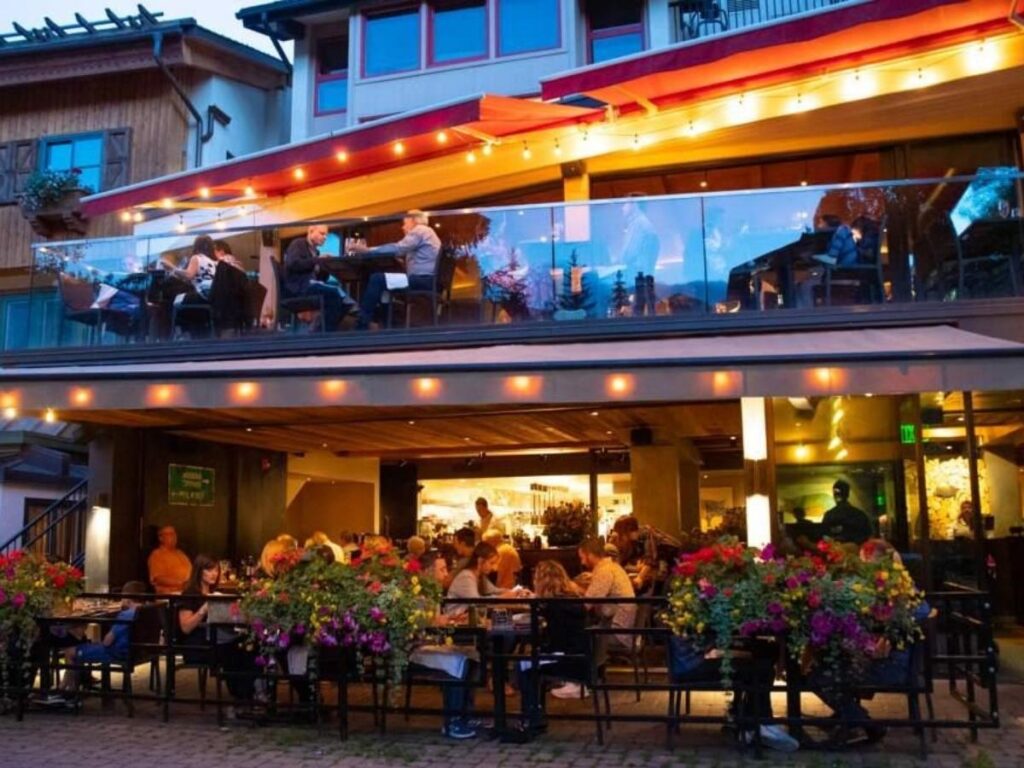 Outdoor dining tables in Vail Village with mountain views in summer
