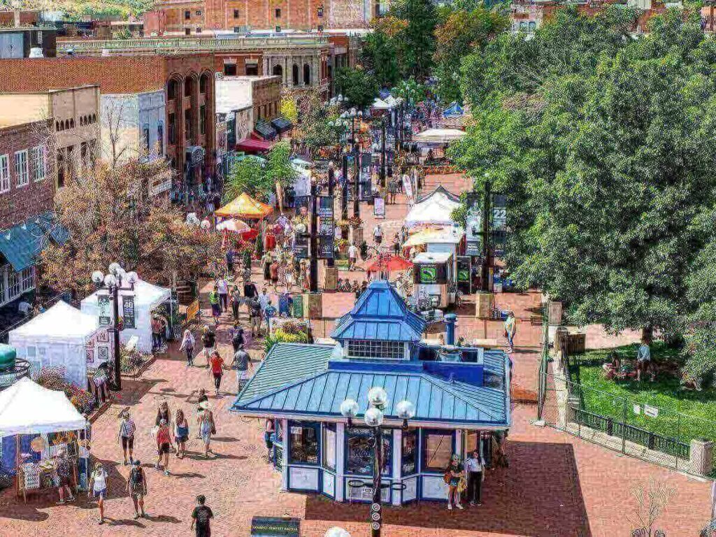Evening on Pearl Street Mall with people walking and café lights glowing.