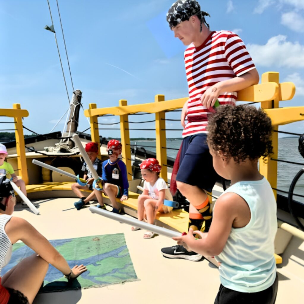 Children dressed as pirates spraying water cannons on a boat cruise