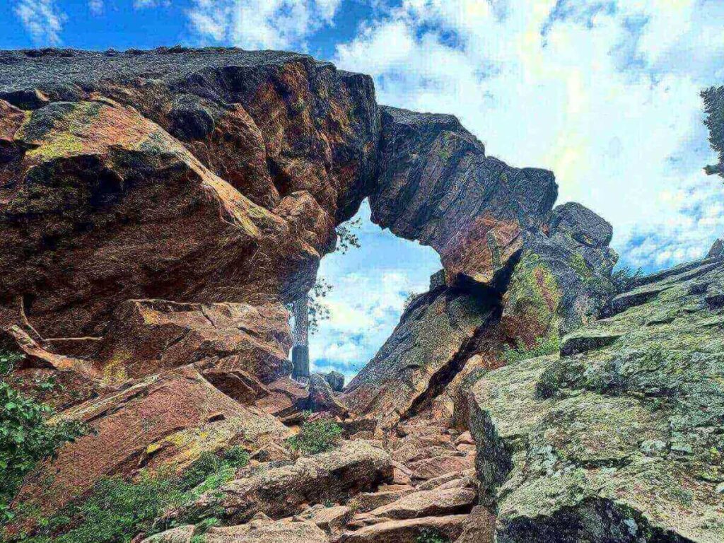 View from Royal Arch trail with sandstone arch and valley below.