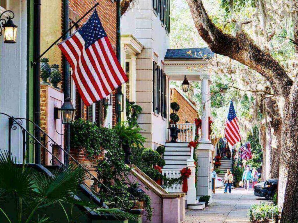 Travelers walking between Savannah’s shaded historic squares on a sunny day