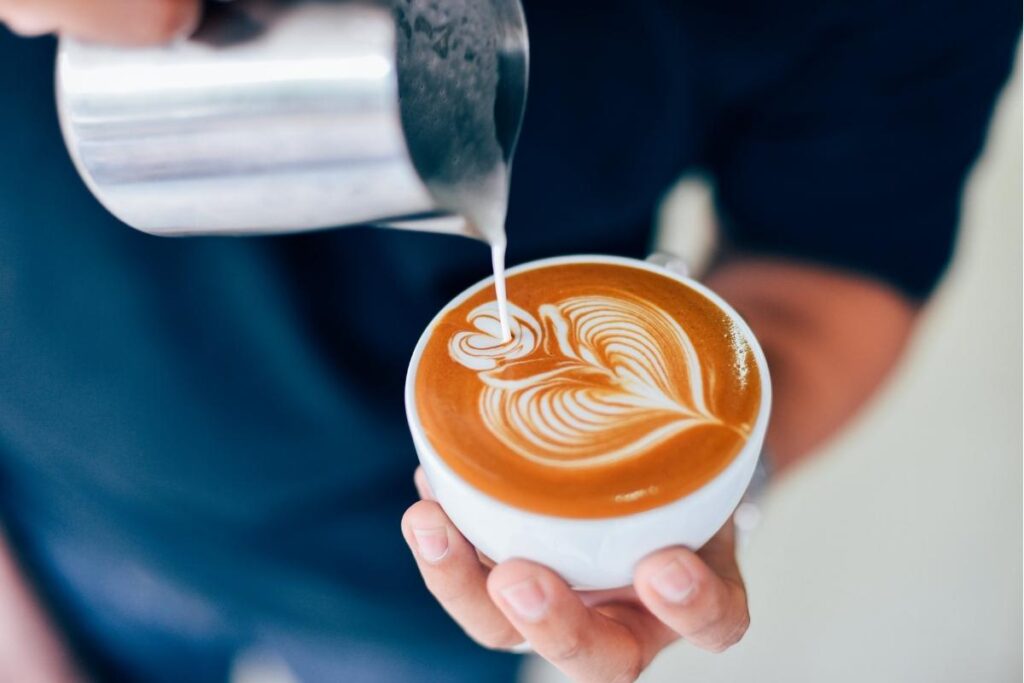 Barista pouring latte art in a Seattle coffee shop