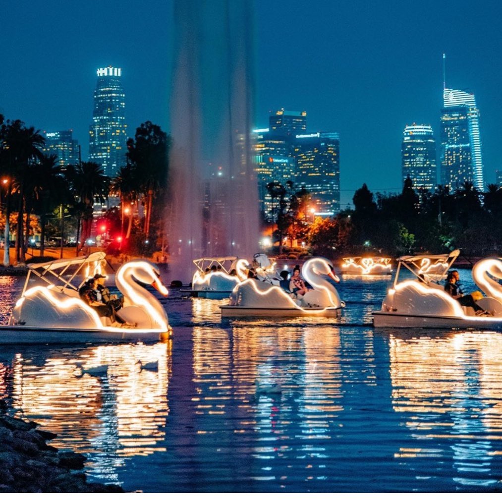 White swan paddle boat floating on Echo Park Lake with downtown LA skyline behind