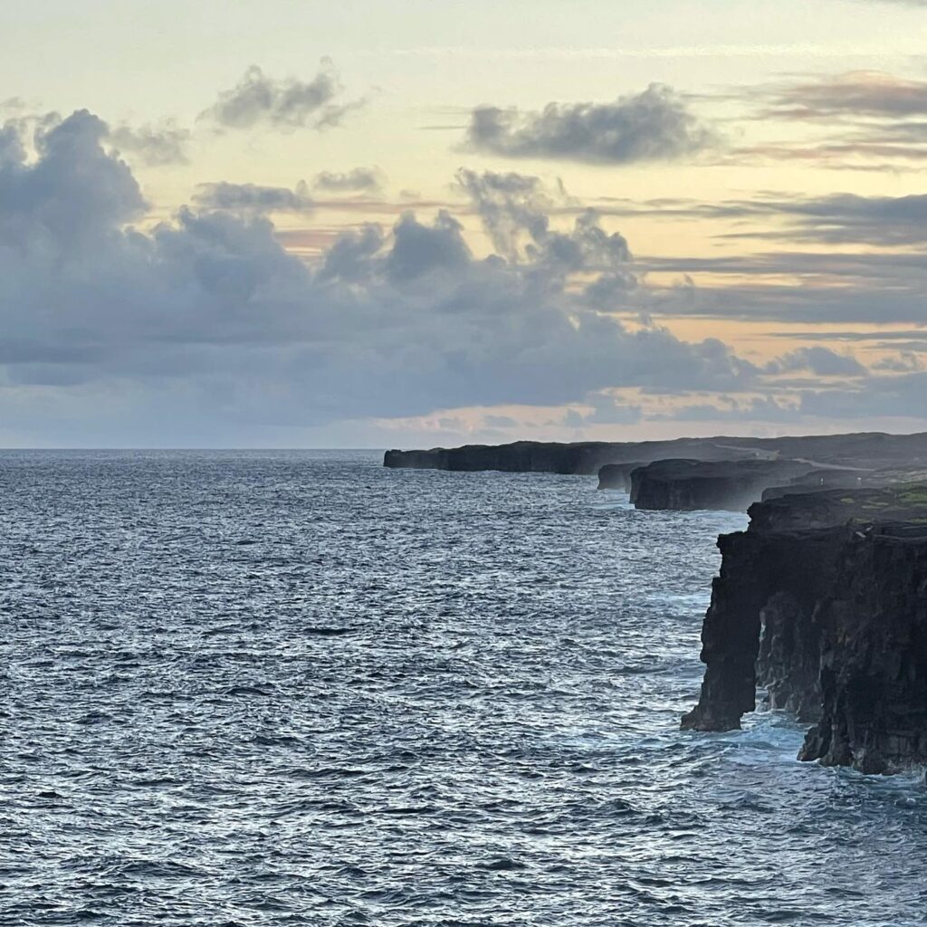 Scenic road cutting through lava fields with ocean in background