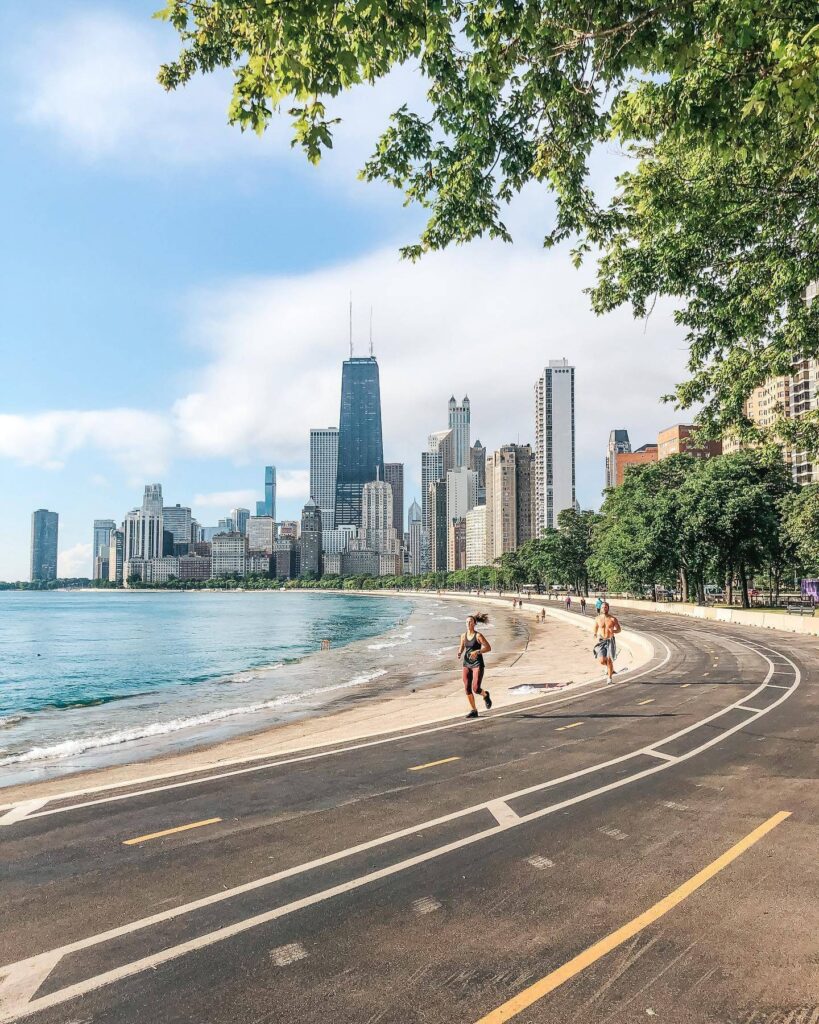 People running along the Lakefront Trail with Chicago skyline in background