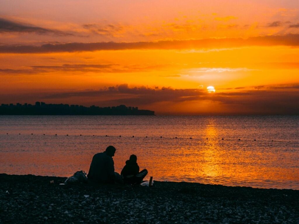 Sunset at Hāʻena State Park beach with mountains in Kauai