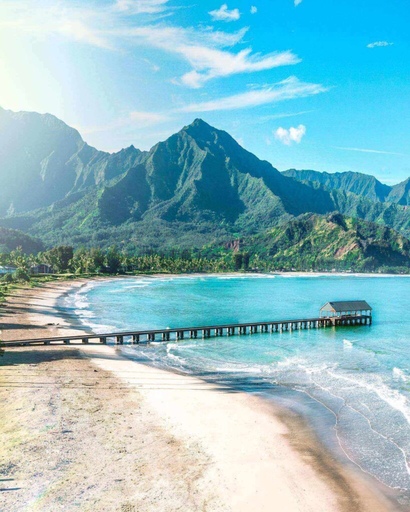 Calm turquoise water and golden sand at Hanalei Bay during summer