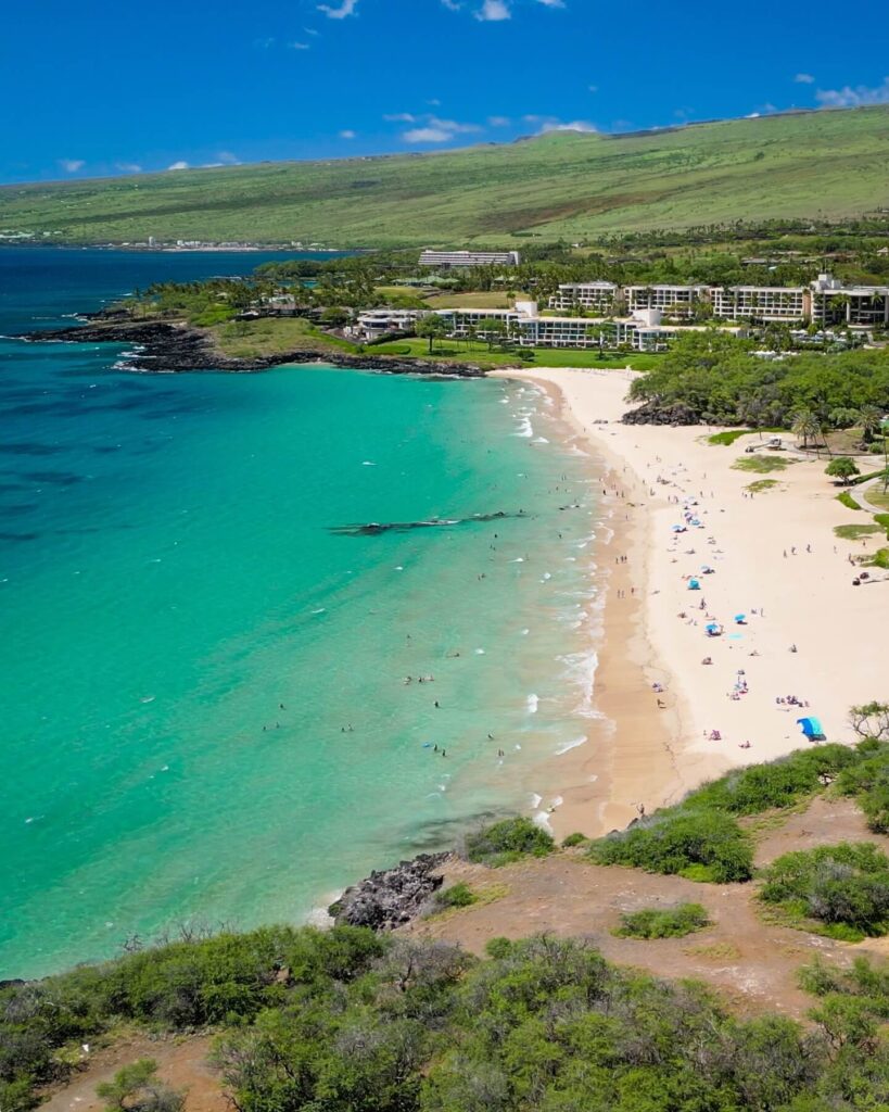 Expansive golden-sand beach with people swimming at Hapuna Beach on the Big Island