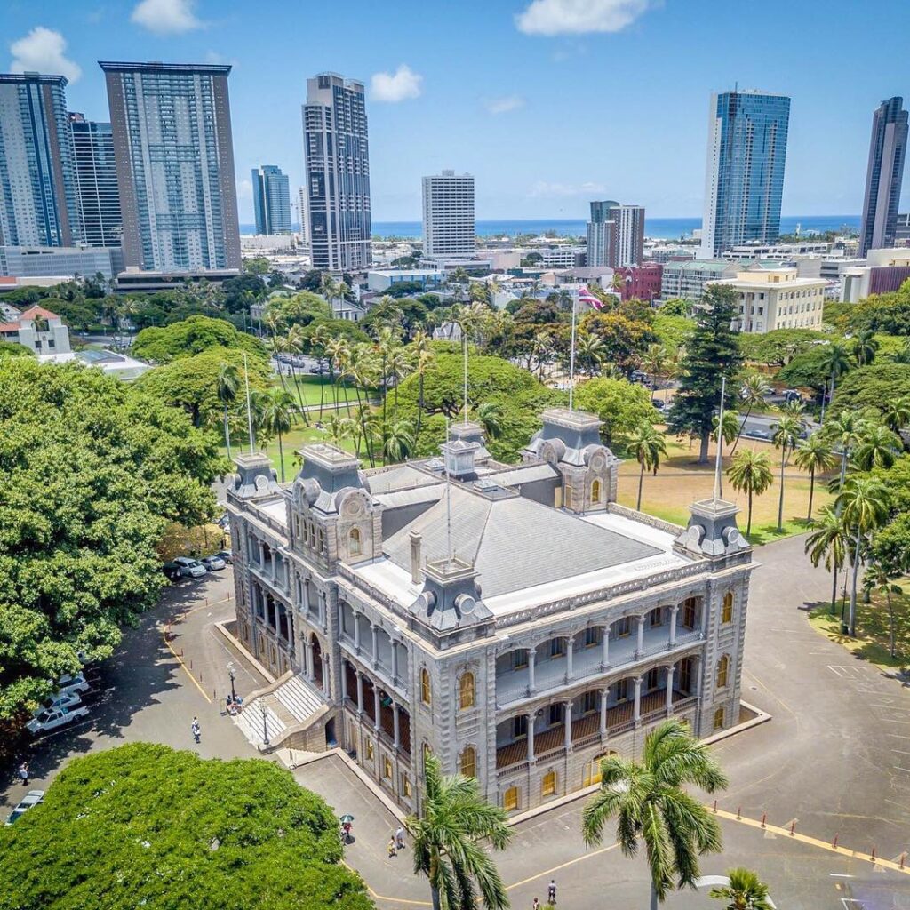 Grand facade of Iolani Palace with palm trees and blue sky