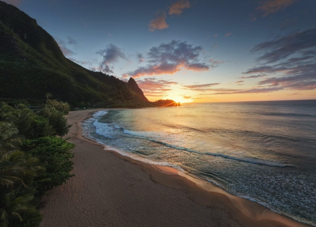 Aerial view of Kauai featuring lush mountains, beaches, and tropical coastline