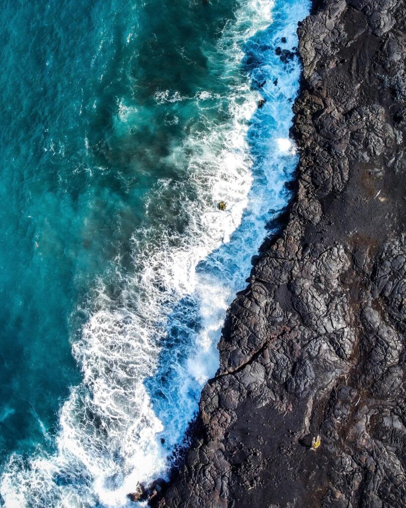 Black sand beach with rugged volcanic rock at Kaimu Beach on the Big Island