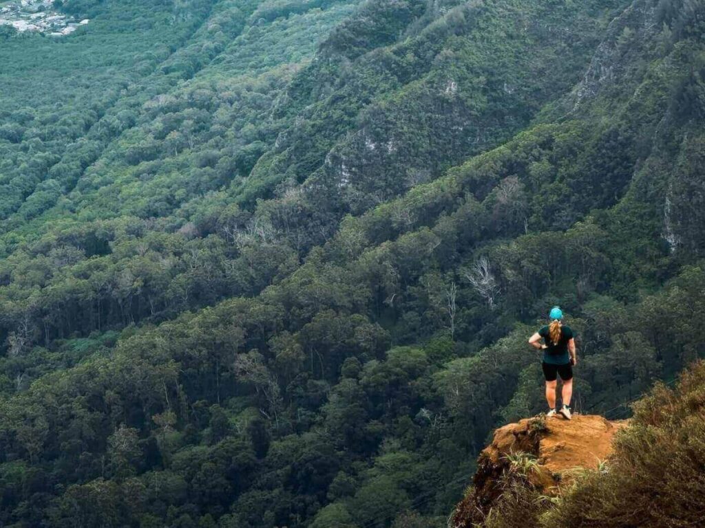 Hikers on Kalalau Trail overlooking the Nā Pali Coast cliffs