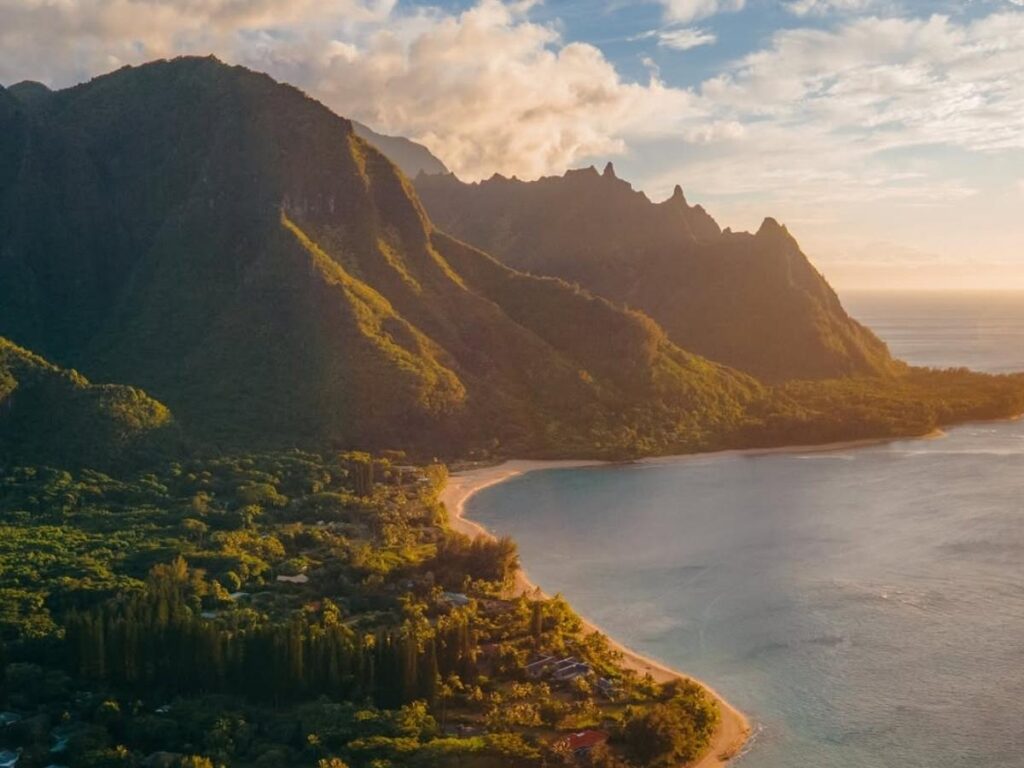 Quiet beach inside a Kauai state park with no buildings and waves rolling onto shore