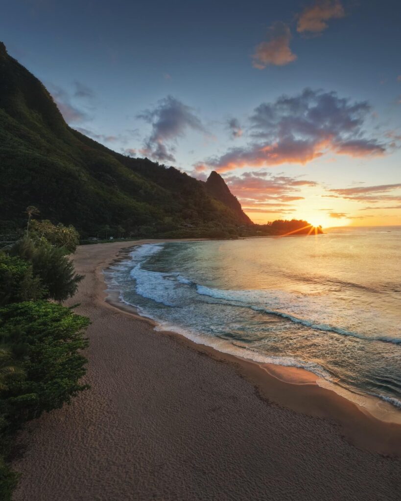 Golden sunset over Hanalei Bay with lush mountains on Kauai