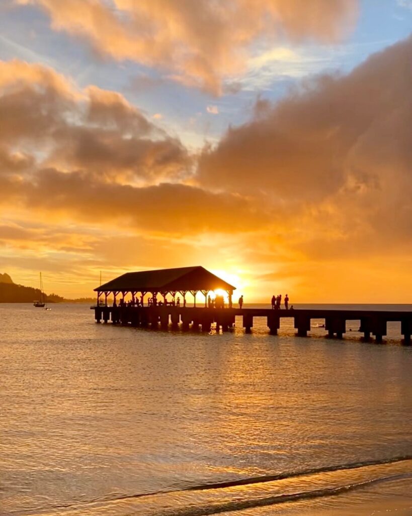 Golden sunset over Hanalei Bay with lush mountains on Kauai