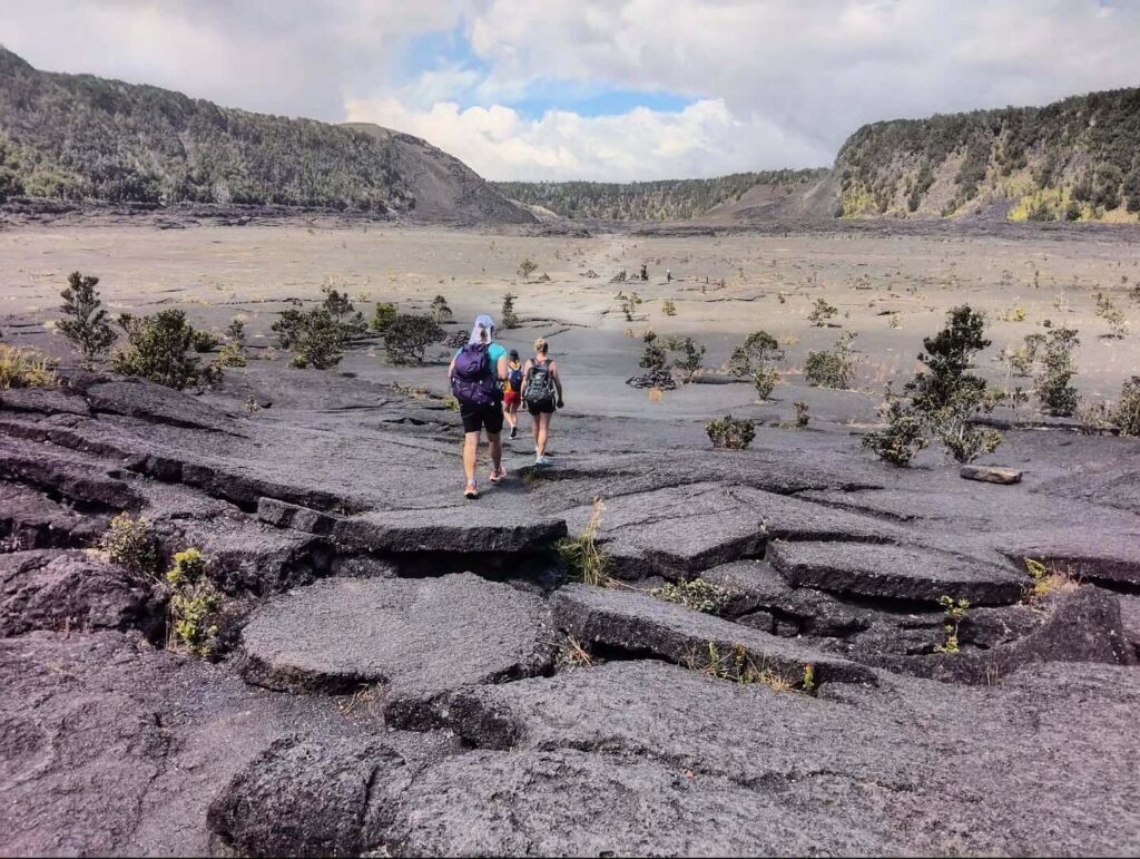 Hiker walking the Kīlauea Iki Trail during spring in Hawaii Volcanoes National Park