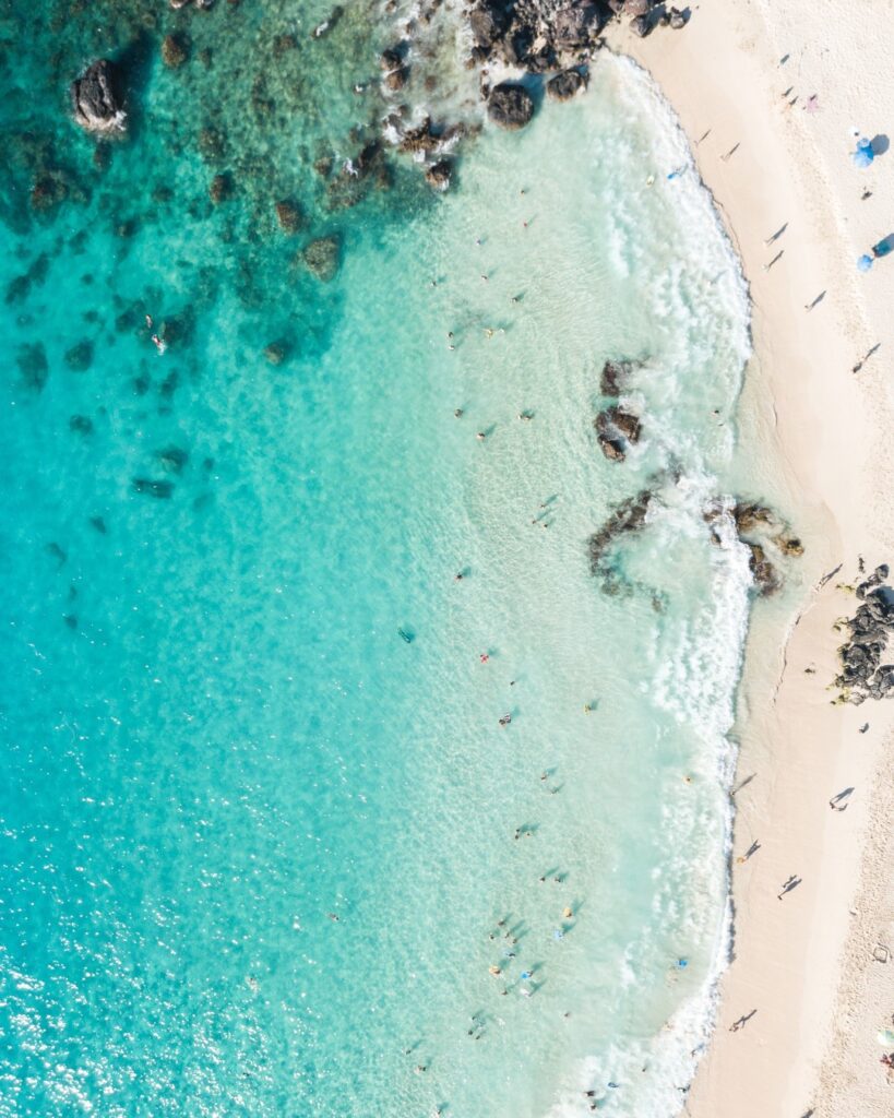Crystal-clear turquoise water and soft white sand at Kua Bay beach in Kona