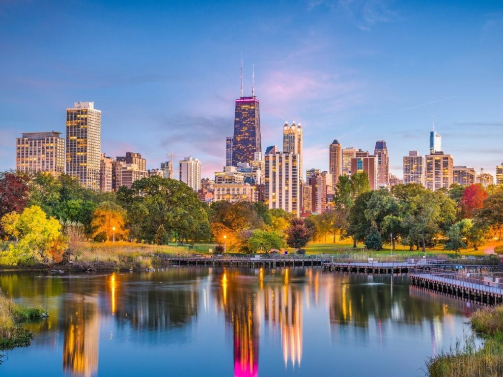 Green lawns and trees in Lincoln Park with the Chicago skyline behind them