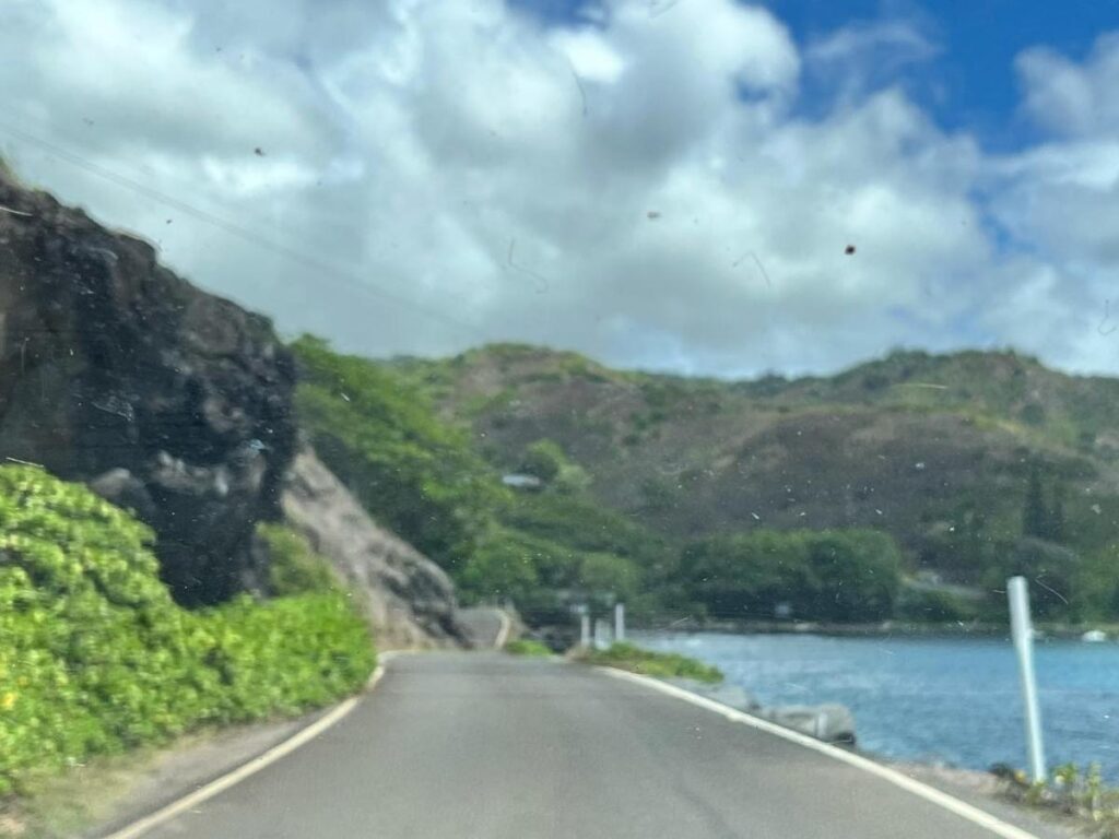 Rental car driving along a quiet coastal road on Molokai