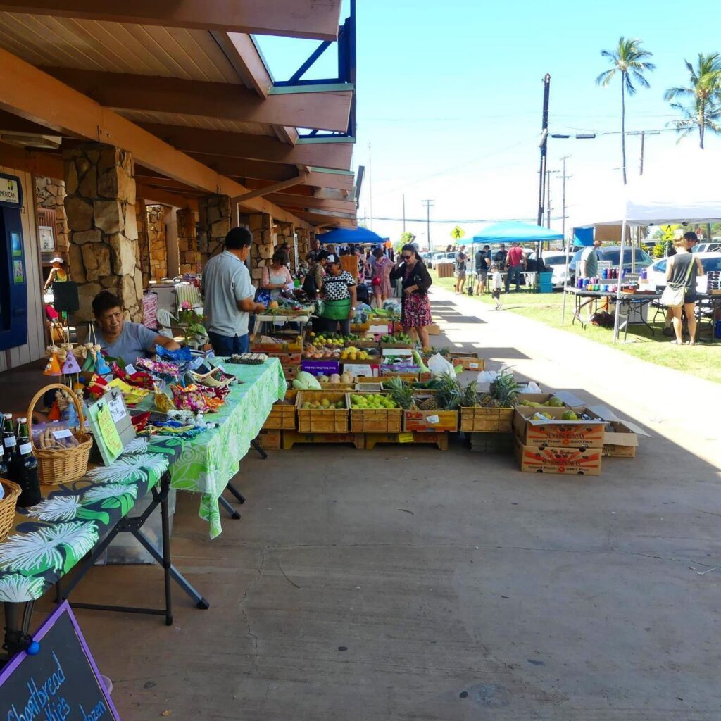 Locals shopping for fresh fruit and handmade crafts at the Saturday farmers market in Kaunakakai