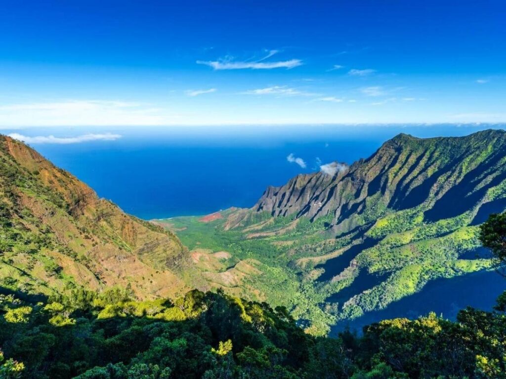 Boat tour cruising along the Nā Pali Coast cliffs in Kauai