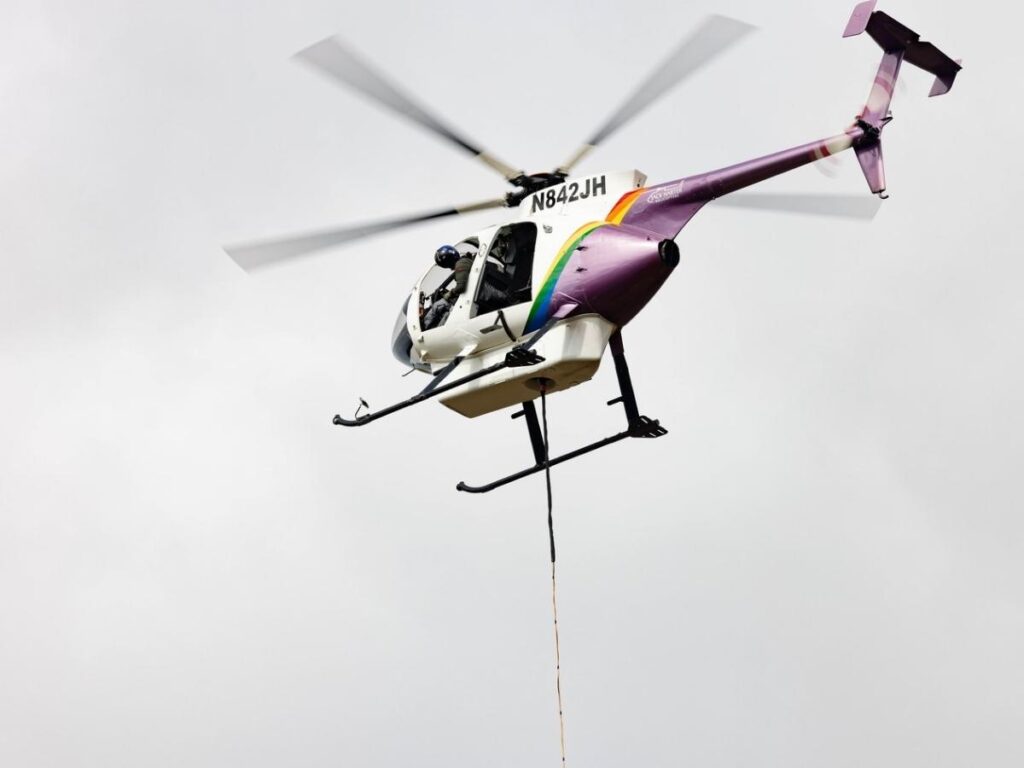 Aerial view of Nā Pali Coast cliffs and waterfalls from helicopter in Kauai