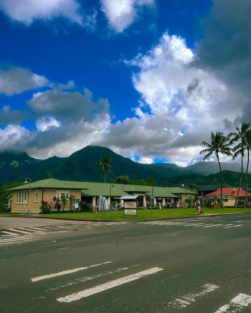 Curving road through lush jungle with views of mountains and ocean on Kauai’s North Shore