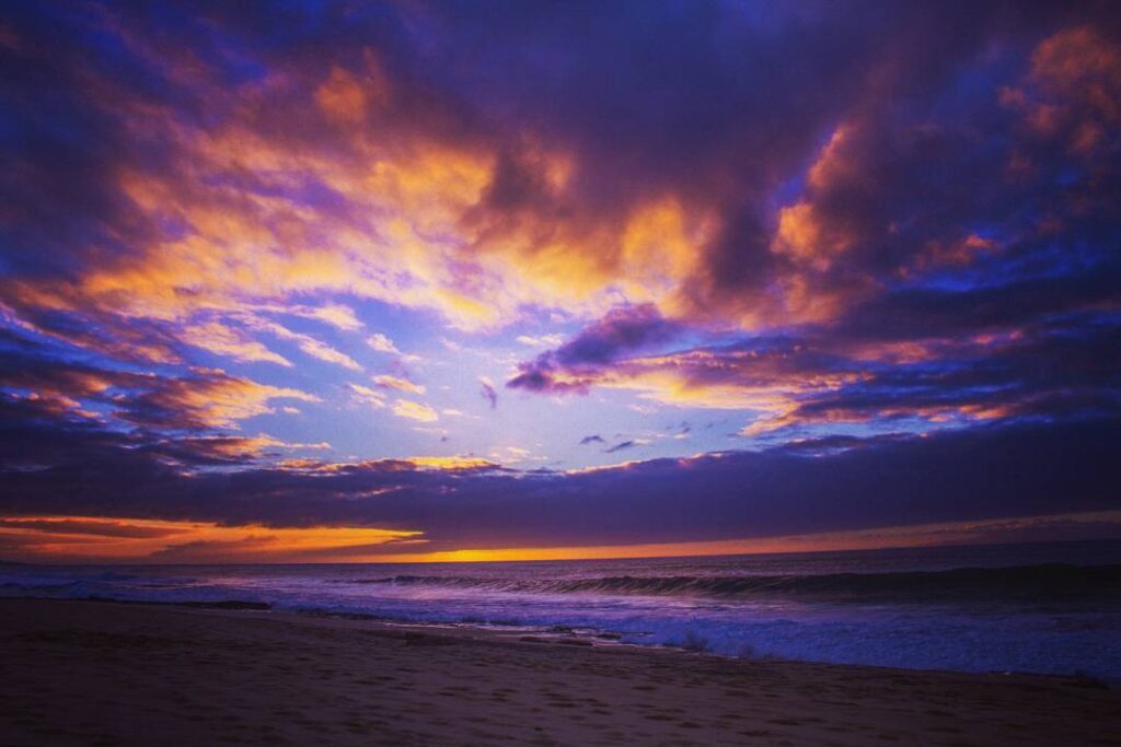 Sunset over Papohaku Beach with golden sky and peaceful shoreline on Molokai