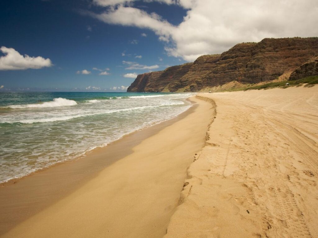 Visitor walking along Polihale Beach during spring on Kauai
