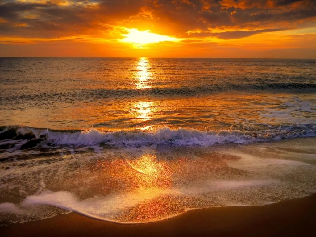 Sunset at Polihale State Park with visitors enjoying the peaceful beach on Kauai