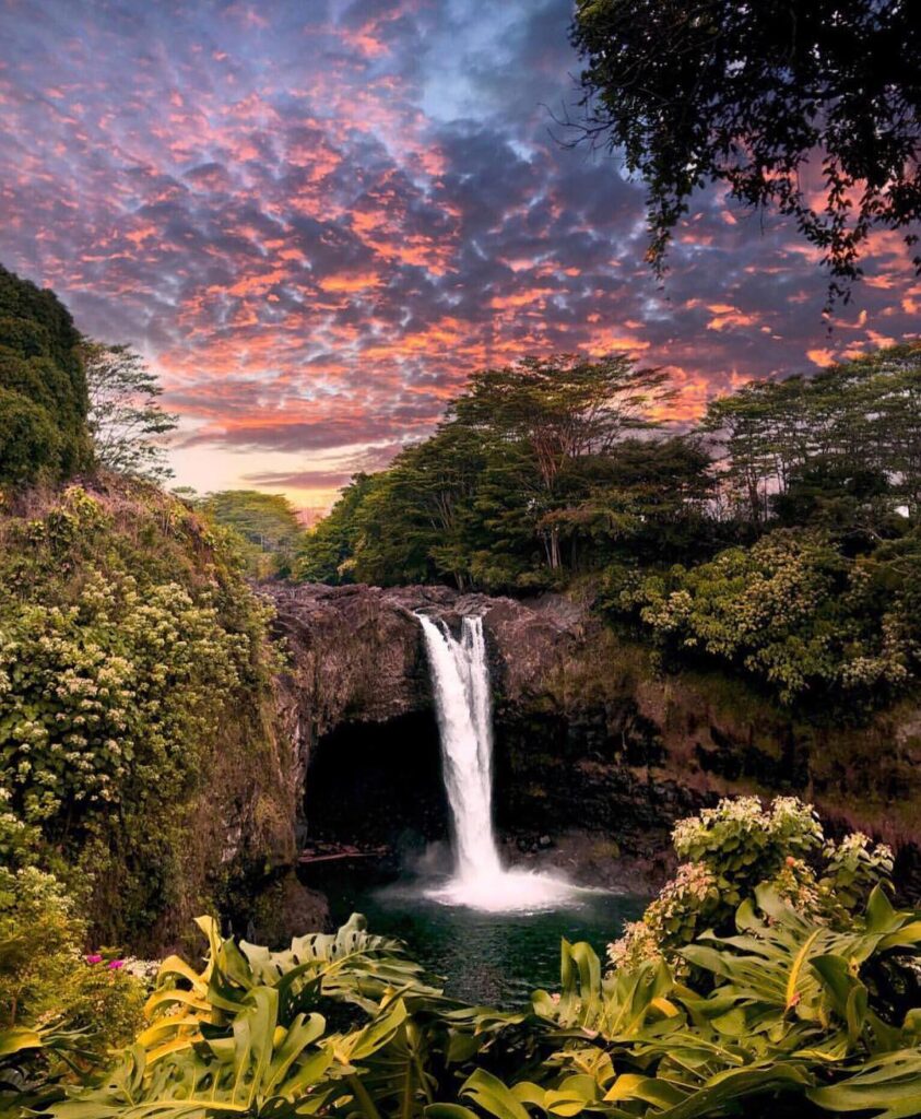 Wide waterfall surrounded by greenery at Rainbow Falls near Hilo