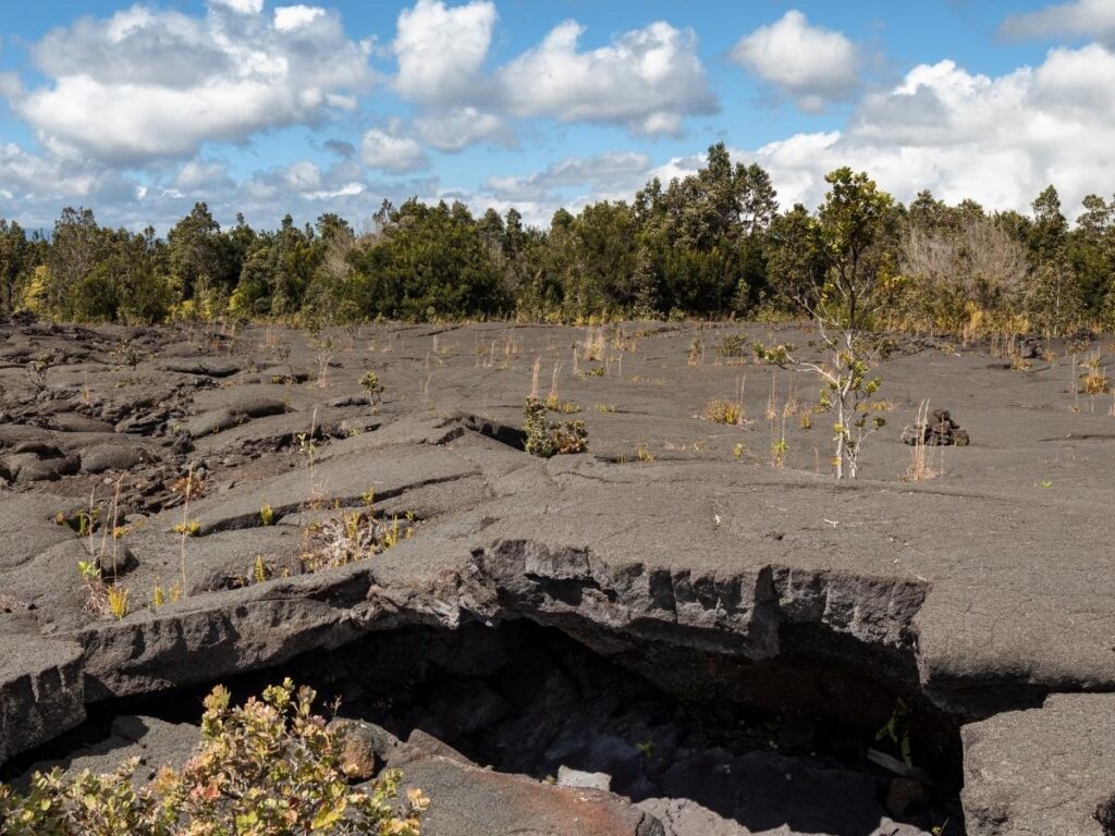 Hiking across rugged lava fields on Mauna Ulu Trail in Hawaiʻi Volcanoes National Park