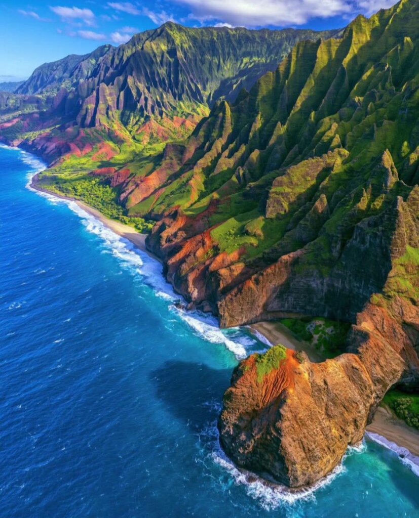 Aerial view of the Na Pali Coast with towering green sea cliffs on Kauai