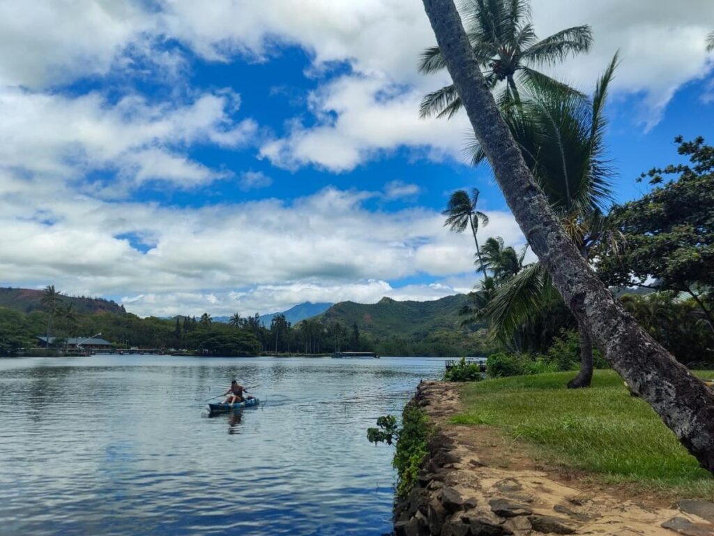 Kayakers paddling on Wailua River in Kauai surrounded by greenery