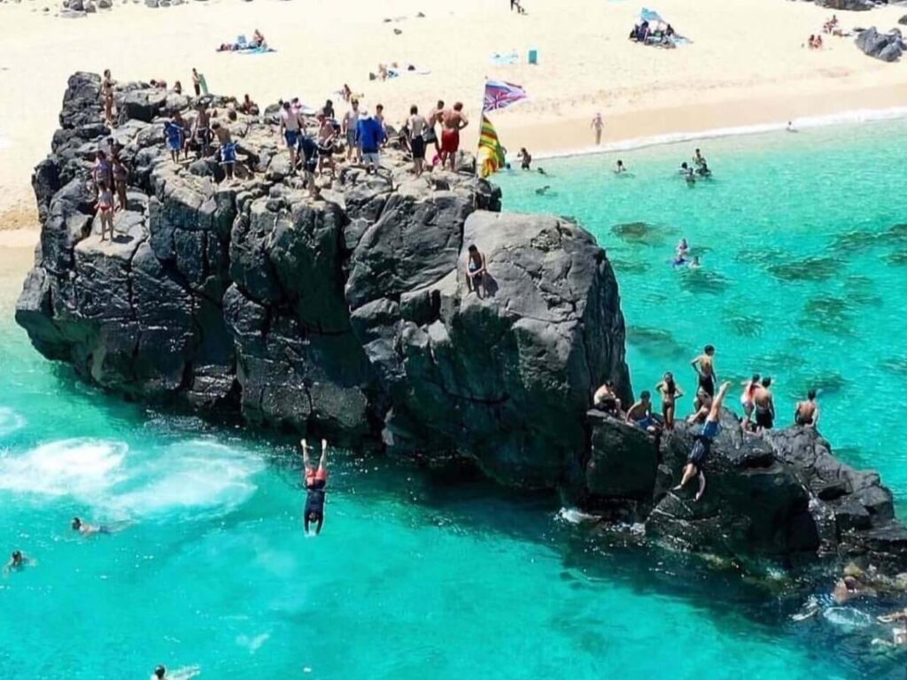 Waimea Bay on Oahu with clear water and rocky cliffs