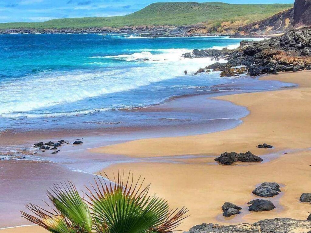 Wide open coastline on the west side of Molokai with dry landscape and blue sky