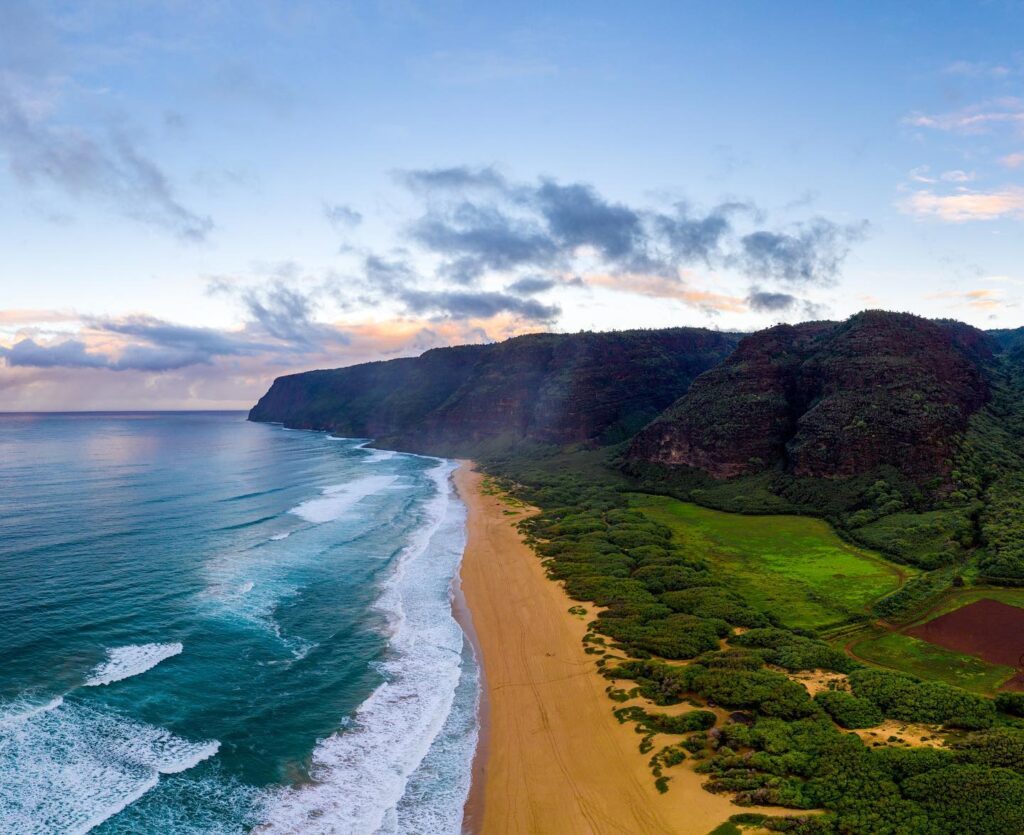 Aerial view of Polihale State Park on the western coast of Kauai with the Nā Pali Coast in the distance