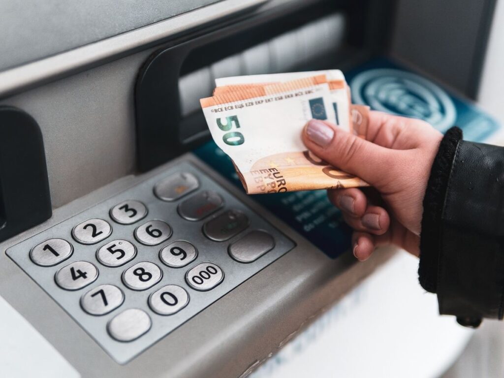 Hand withdrawing euros from ATM